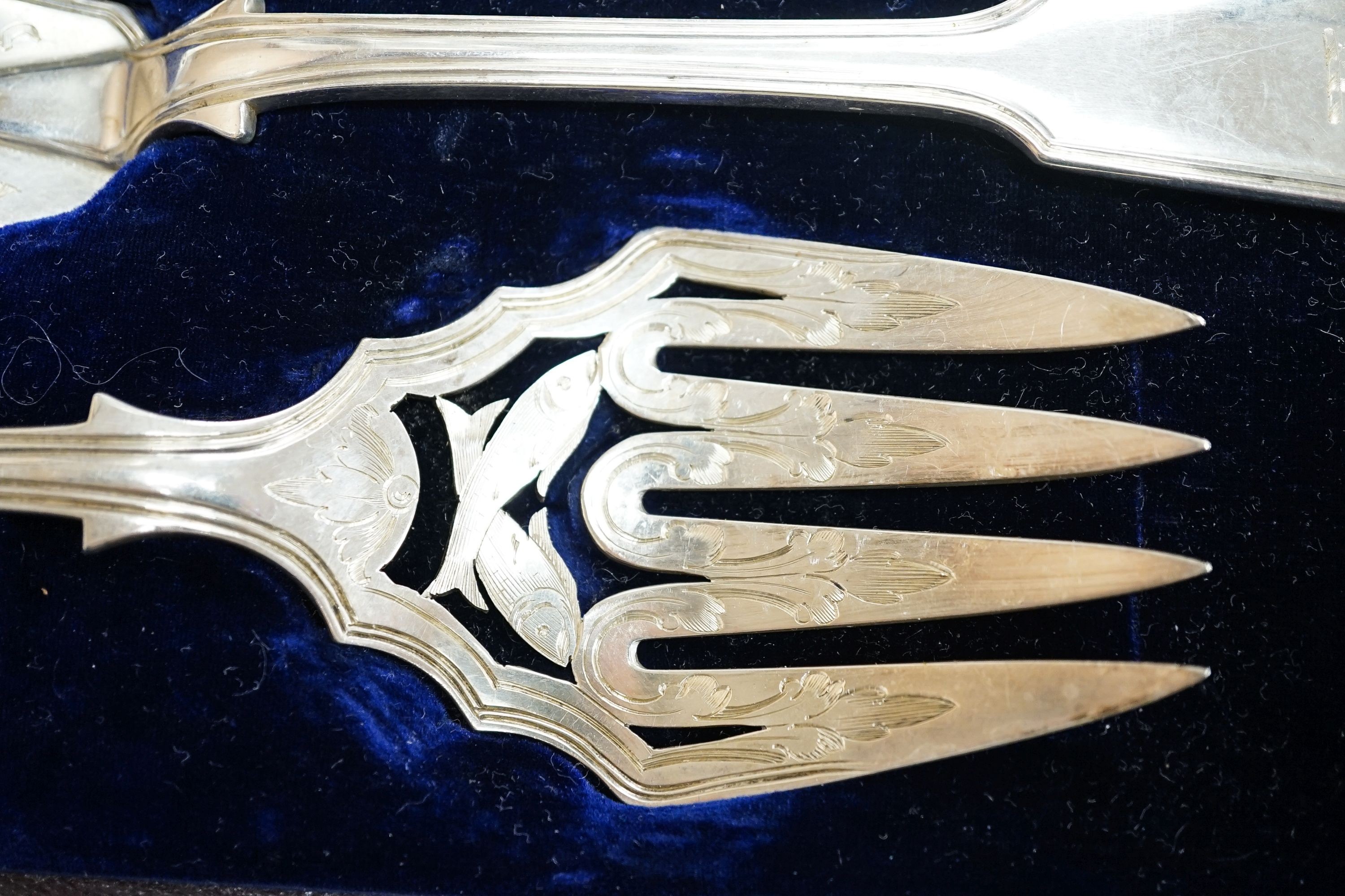A cased pair of Victorian silver fish servers, London, 1856, together with a cased set of four George V pierced silver oval salts with cobalt blue glass liners (no spoons).